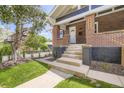 Inviting entryway with concrete steps, a well-kept lawn, and a classic brick facade at 3922 W 29Th Ave, Denver, CO 80212