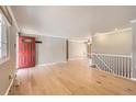 Bright living room features hardwood floors and a red front door at 6259 S Fenton Ct, Littleton, CO 80123