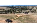 Scenic aerial view of the home nestled among trees with a sprawling landscape and distant mountains at 37094 Still Rock Pt, Elizabeth, CO 80107