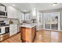 Bright kitchen featuring a center island, stainless appliances, and a sliding patio door at 3183 W 114Th Loop, Westminster, CO 80031