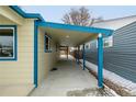 Covered side porch with blue accents and a concrete floor at 1770 Akron St, Aurora, CO 80010