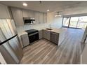 Stylish kitchen with stainless steel appliances, quartz counters, herringbone backsplash, and abundant natural light at 100 Park Ave # 1405, Denver, CO 80205