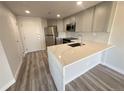 Modern kitchen featuring stainless appliances, quartz counters, and gray cabinets at 100 Park Ave # 1405, Denver, CO 80205