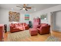 Cozy living room features a red leather sofa and armchair on a decorative rug with hardwood floors at 5567 E Asbury Ave, Denver, CO 80222