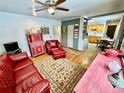Cozy living room features wood floors, ceiling fan, and decorative red furniture at 5567 E Asbury Ave, Denver, CO 80222