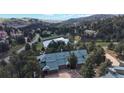 Scenic aerial view of an estate surrounded by lush forest and a private pond at 867 Hill And Dale Rd # B, Golden, CO 80401