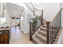 Bright entryway with staircase featuring wood and metal accents, complemented by stylish decor and light wood floors at 1953 Morgan Dr, Erie, CO 80516