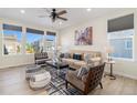 Inviting living room with large windows, comfortable seating, ceiling fan, and decorative rug at 1953 Morgan Dr, Erie, CO 80516