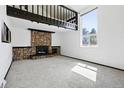 Cozy living room featuring a stone fireplace and large windows for ample natural light at 5197 S Perry St, Littleton, CO 80123