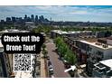 A street view of modern townhomes in an urban setting, with the Denver skyline in the background at 2650 W Front View Crescent Dr # 101, Denver, CO 80211