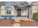 Inviting covered front porch with flower planters and wooden deck leads to an ornate front door at 160 W Bayaud Ave, Denver, CO 80223