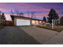 Charming single-story home boasting a brick facade, attached garage, and lush lawn at dusk at 3565 S Holly St, Denver, CO 80237