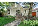 A cozy home features a unique brick exterior and meticulously maintained yard, surrounded by mature shade trees at 1731 Locust St, Denver, CO 80220