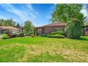Traditional home showcasing meticulously maintained landscaping and vibrant green lawns at 2901 Monaco Pkwy, Denver, CO 80207