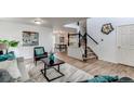 Bright living room featuring modern decor, hardwood floors, and an open staircase leading to the upper level at 11183 E 114Th Ave, Commerce City, CO 80640