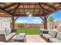 Outdoor patio features a wooden pergola with decorative lights, a stone tile floor and outdoor seating at 8240 Clayton Ct, Denver, CO 80229
