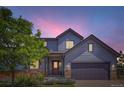 Charming two-story home featuring a well-maintained yard and inviting front entrance at twilight at 2150 Wagon Way, Louisville, CO 80027