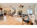 Open-concept living room with hardwood floors, stone fireplace, and staircase at 2150 Wagon Way, Louisville, CO 80027