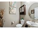 Stylish half bathroom with decorative art and a vintage-inspired mirror and vanity at 2636 Scoter Ln, Castle Rock, CO 80104