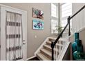 Bright foyer featuring a staircase with carpeted steps, a white banister, and decoratively adorned walls at 2636 Scoter Ln, Castle Rock, CO 80104