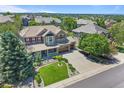 An aerial view of a two-story home with a well-kept lawn, complemented by mature trees and a three-car garage at 19616 E Pinewood Dr, Aurora, CO 80016
