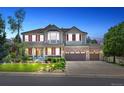 Inviting two-story home at twilight with a covered front porch, manicured lawn, and a three-car garage at 19616 E Pinewood Dr, Aurora, CO 80016