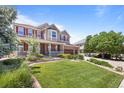 Beautifully landscaped front yard leading to a charming two-story home with a welcoming covered porch at 19616 E Pinewood Dr, Aurora, CO 80016