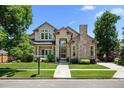 Inviting two-story home with lush landscaping and a classic brick facade at 222 S Olive St, Denver, CO 80230