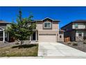 Inviting two-story home featuring a neutral color scheme, well-maintained lawn, and a two-car garage at 2325 Mountain Sky Dr, Fort Lupton, CO 80621