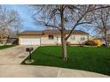 Charming single-story home features a well-maintained lawn, mature trees, and an attached two-car garage at 16397 E Wyoming Dr, Aurora, CO 80017