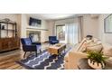 Bright living room with a fireplace, blue chairs, and a sliding glass door to an outdoor space at 7250 Eastmoor Dr # 119, Denver, CO 80237