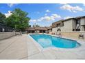 Community pool with ample seating surrounded by well-maintained landscaping and building features at 7250 Eastmoor Dr # 119, Denver, CO 80237