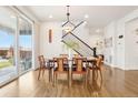 Bright dining room with hardwood floors, stylish lighting, and a large sliding glass door at 13960 Box Turtle Loop, Parker, CO 80134