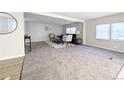 Open-concept living room with fresh paint, carpet, and bright windows offering plenty of sunlight at 2032 Tulane St, Denver, CO 80260