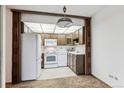 Bright kitchen features wood cabinets and white appliances at 635 S Alton Way # 1C, Denver, CO 80247