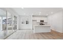 Bright kitchen with white cabinets, a center island, and sliding glass doors at 1362 Rock Cliff Ave, Erie, CO 80516