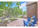 Inviting front porch featuring comfortable blue chairs and charming brickwork, perfect for relaxing outdoors at 926 S Fillmore Way, Denver, CO 80209