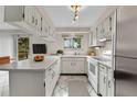 Efficient white kitchen with stainless steel appliances, bright lighting, and tile flooring at 3061 W 92Nd Ave # 8B, Westminster, CO 80031
