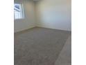 A carpeted bedroom featuring a large window and neutral paint tones at 6731 Arbor E Blvd, Thornton, CO 80602