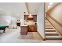 Finished basement with a bar, tiled floors, and a cozy fireplace seating area at 20401 High Pines Dr, Monument, CO 80132