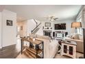 Spacious living room with a fireplace, staircase, modern decor, and hardwood floors at 25128 E Maple Ave, Aurora, CO 80018