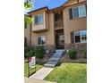 Inviting two-story townhome with a private balcony, stone accents, and manicured lawn at 1211 Bistre St, Longmont, CO 80501