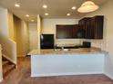 Kitchen featuring dark cabinets, updated appliances, and a convenient breakfast bar at 1211 Bistre St, Longmont, CO 80501