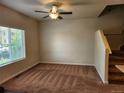 Inviting living room with neutral walls, plush carpet, and a ceiling fan for comfort at 1211 Bistre St, Longmont, CO 80501