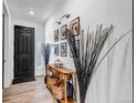 Inviting entryway featuring wood-look flooring, console table with decor, and a view of the front door at 2089 S Fultondale Way, Aurora, CO 80018