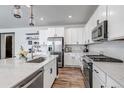 Modern kitchen featuring white cabinets, stainless steel appliances, and hardwood floors at 2089 S Fultondale Way, Aurora, CO 80018