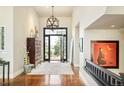 Spacious foyer featuring hardwood floors, a stylish light fixture, and an inviting view through the front door to the exterior at 5425 S University Blvd, Greenwood Village, CO 80121
