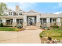 A charming home with a welcoming covered porch, stone details, and meticulously maintained landscaping leading to the front entrance at 5425 S University Blvd, Greenwood Village, CO 80121