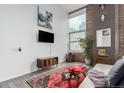 Bright living room features large windows, hardwood floors, exposed brick, and modern decor at 720 16Th St # 505, Denver, CO 80202