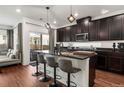 Modern kitchen featuring dark cabinetry, granite countertops, an island with bar seating, and stainless steel appliances at 10226 Worchester St, Commerce City, CO 80022